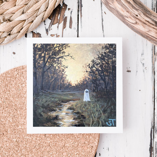 Note card featuring artwork of a ghost by a stream in a forest setting, displayed on a textured background.