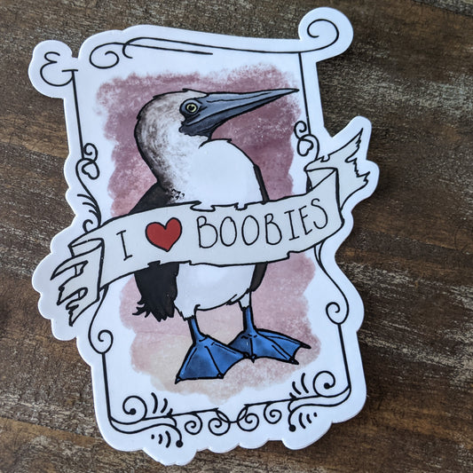 A sticker with an illustration of a Blue-Footed Booby and the phrase 'I love BOOBIES' written on it, with a heart symbol representing the word 'love'.
