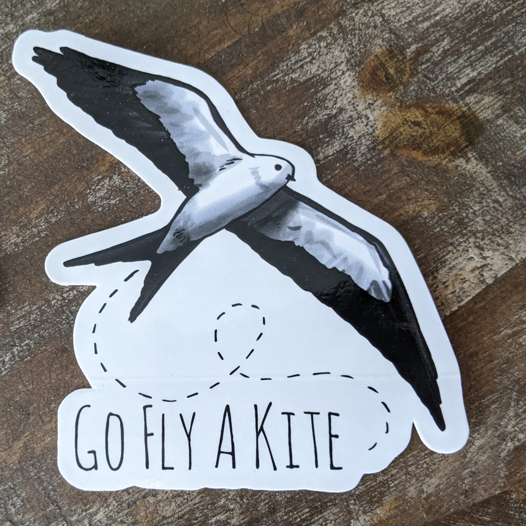 A decorative sticker with a black and white kite illustration and the phrase 'GO FLY A KITE' in bold letters.