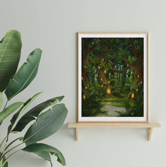 A framed art print depicting a whimsical, enchanted forest scene displayed on a wooden shelf with a green plant beside it.